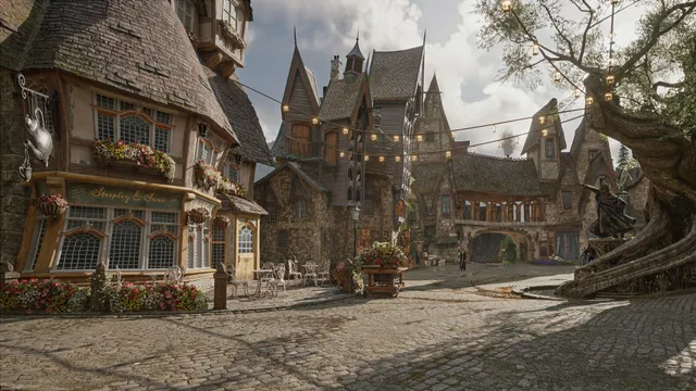 Praça empedrada de uma vila em Hogwarts Legacy, com casas de telhados inclinados, flores nas janelas, luzes penduradas e uma árvore retorcida à direita