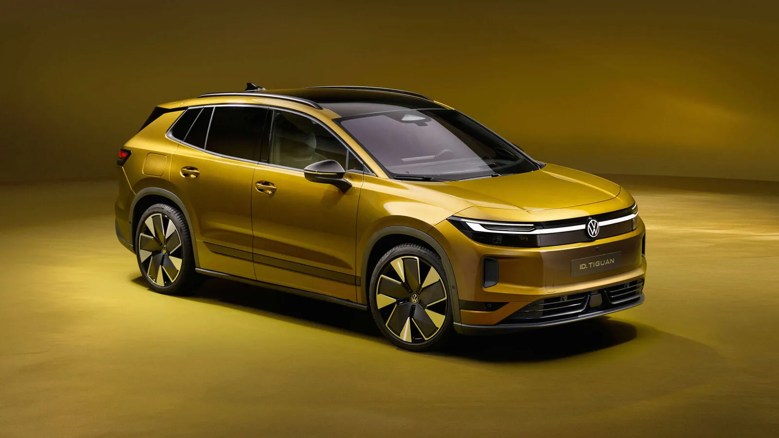 Volkswagen ID. Tiguan dourado visto de frente a três quartos, num estúdio com fundo em tons de ouro