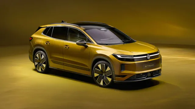 Volkswagen ID. Tiguan dourado visto de frente a três quartos, num estúdio com fundo em tons de ouro