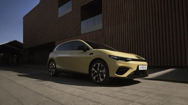 Leapmotor B05 amarelo estacionado em frente a um edifício revestido a ripas castanhas, visto de três quartos pela frente