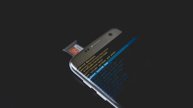 Telemóvel Android pousado numa superfície escura, com o tabuleiro do cartão aberto e texto do modo de recuperação no ecrã