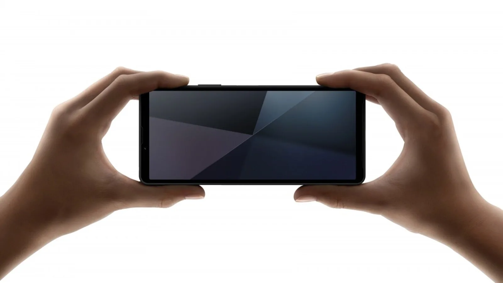 Duas mãos seguram um Sony Xperia 10 VI preto na horizontal, com o ecrã ligado, sobre fundo branco