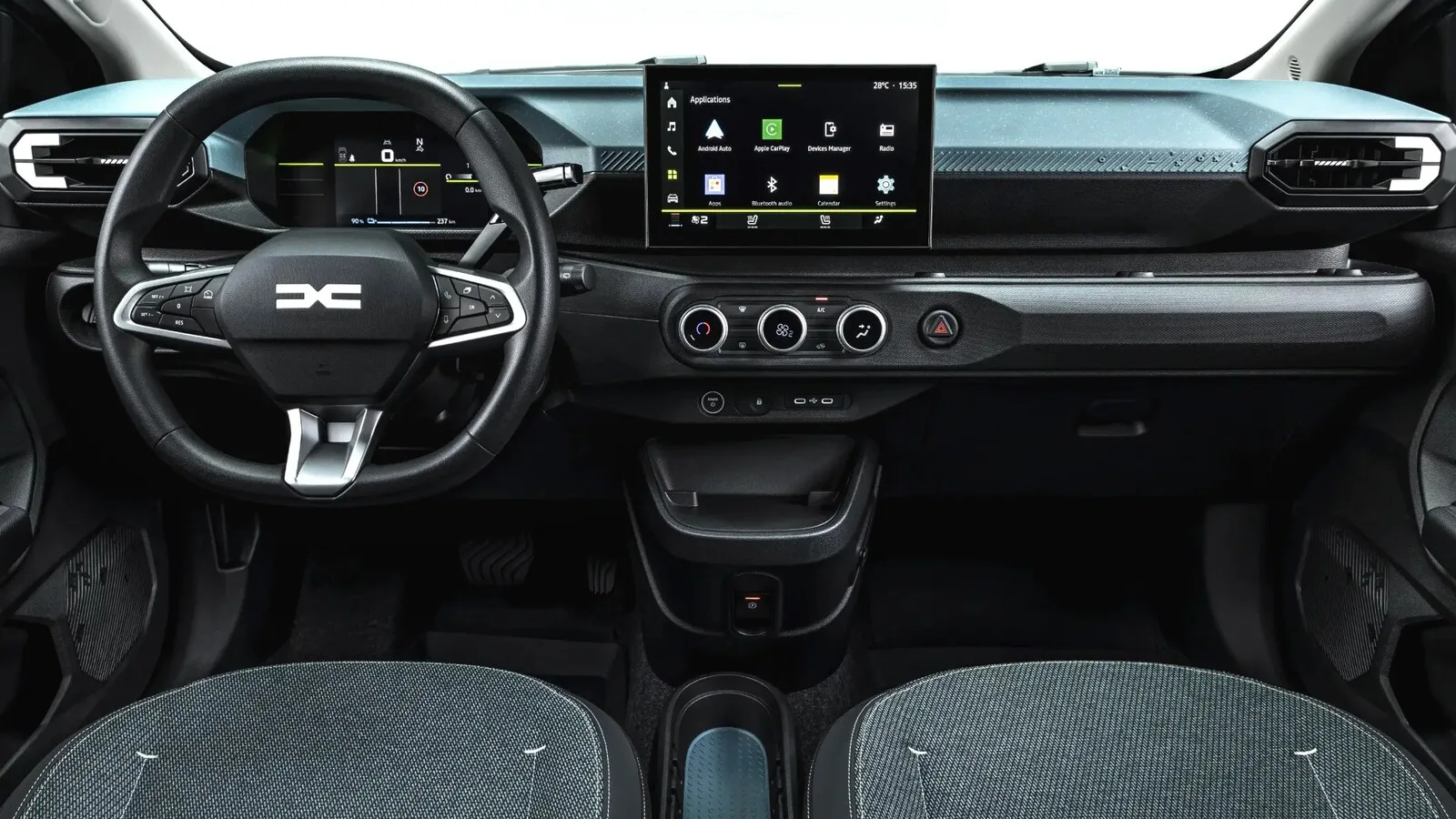 Tablier de um carro com volante de logótipo Dacia, painel de instrumentos digital, ecrã central com menu de aplicações e comandos da climatização