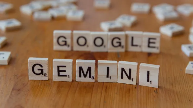 Peças de madeira de um jogo de palavras alinhadas a formar as palavras Google e Gemini, em cima de uma mesa
