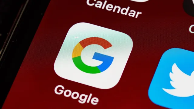 Ecrã de telemóvel visto de perto com o ícone da app Google em destaque, entre os ícones do calendário e do Twitter