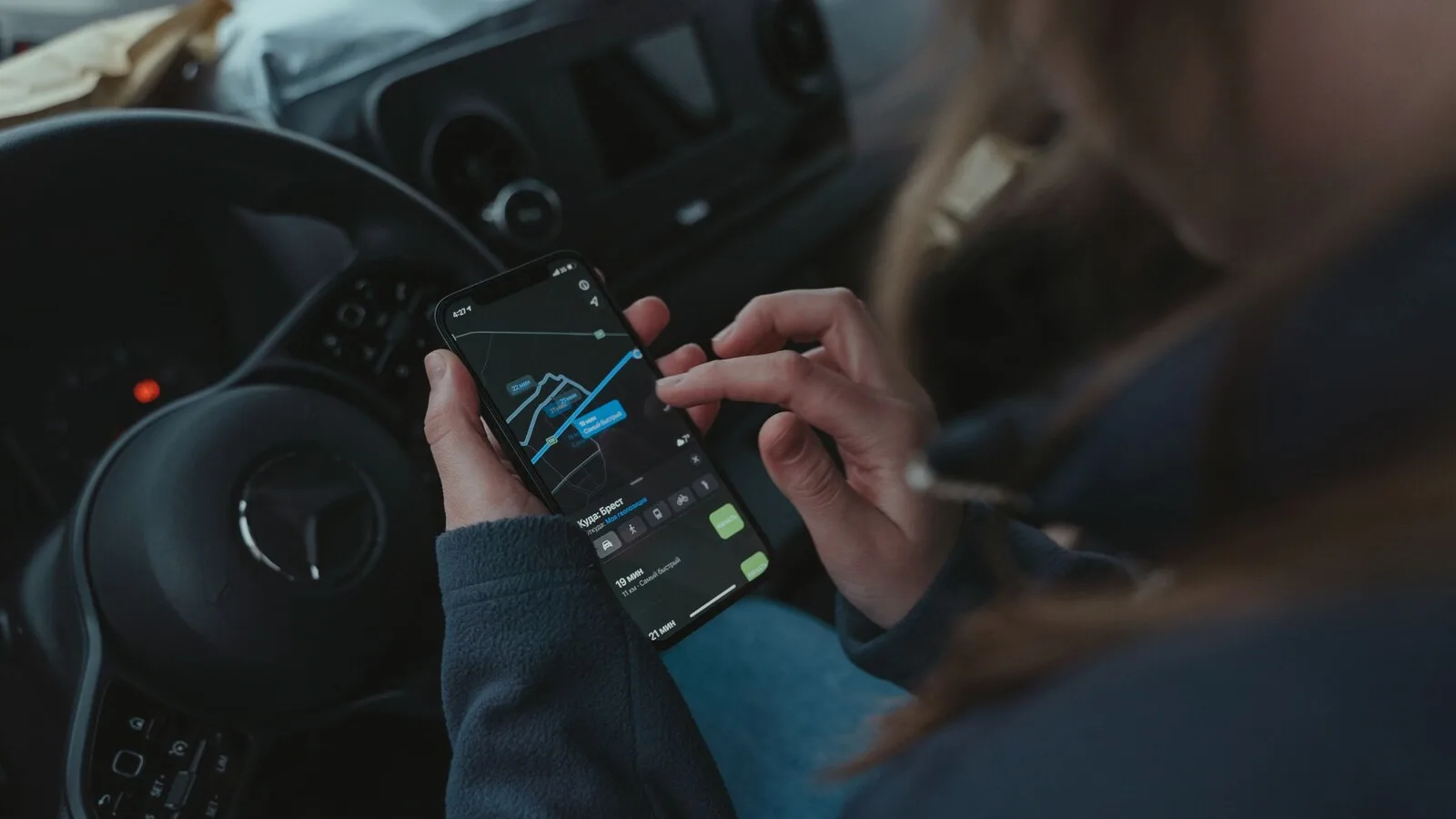 Pessoa sentada ao volante de um carro parado a usar o telemóvel