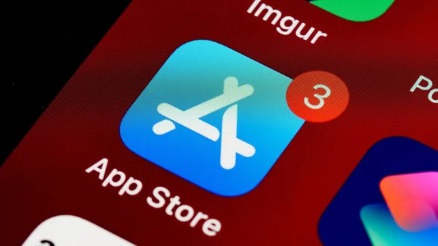 Grande plano do ícone azul da App Store no ecrã de um iPhone, com um aviso de três atualizações