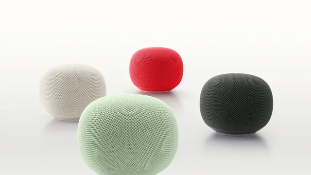 Quatro colunas Google Home Speaker redondas, revestidas de tecido, em verde-claro, bege, vermelho e cinzento-escuro, sobre um fundo branco