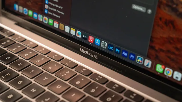 Grande plano do teclado de um MacBook Air prateado, com a barra de aplicações do macOS visível no ecrã