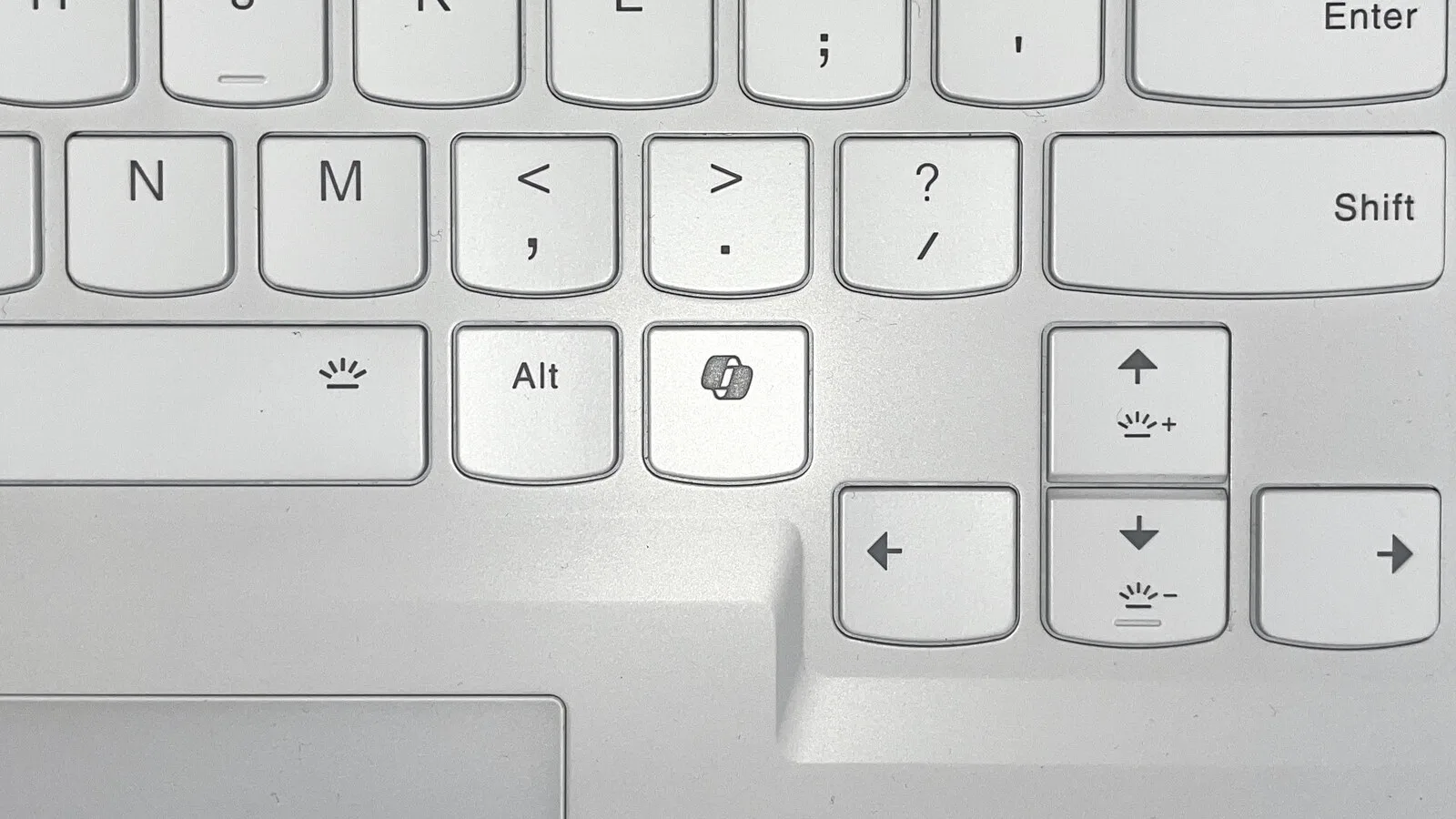Teclado de portátil branco com a tecla do Copilot ao lado da tecla Alt, junto às setas de direção