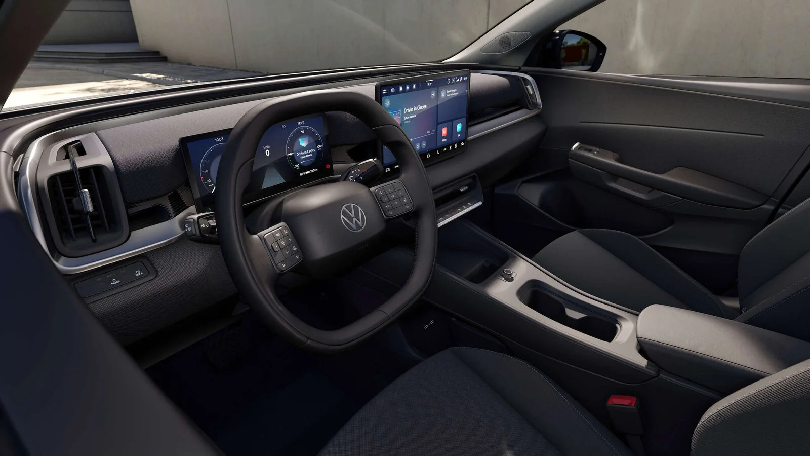 Interior do Volkswagen ID. Cross com volante de base plana, painel de instrumentos digital, ecrã central grande e bancos em tecido escuro