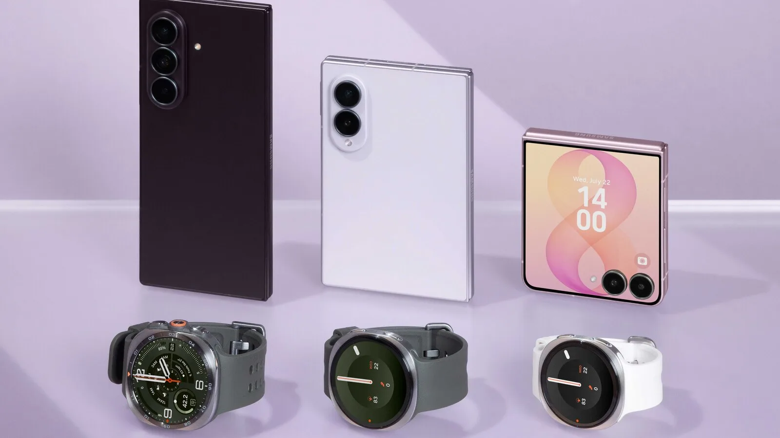 Três telemóveis dobráveis Samsung fechados, um preto alto, um branco mais largo e um cor-de-rosa pequeno com ecrã exterior, à frente de três relógios inteligentes, sobre fundo lilás