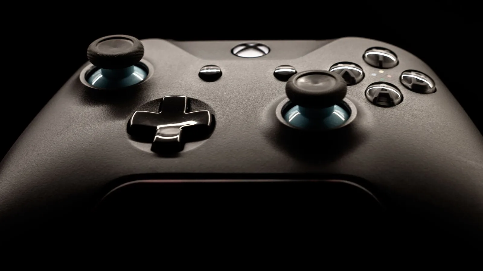 Comando Xbox preto visto de perto, sobre fundo escuro