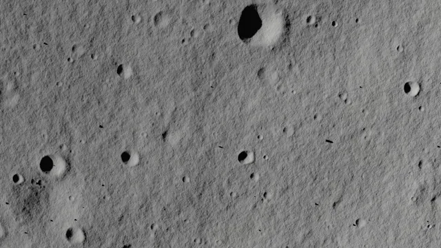 Superfície cinzenta da Lua vista de cima, salpicada de pequenas crateras com sombras escuras