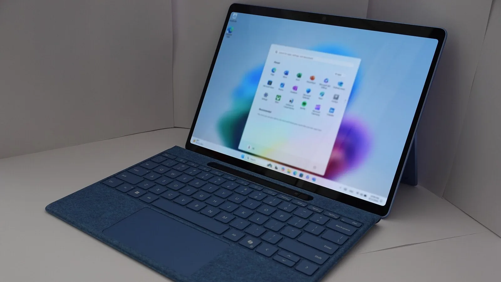 Computador portátil Surface com teclado azul, com o menu Iniciar do Windows 11 aberto no ecrã