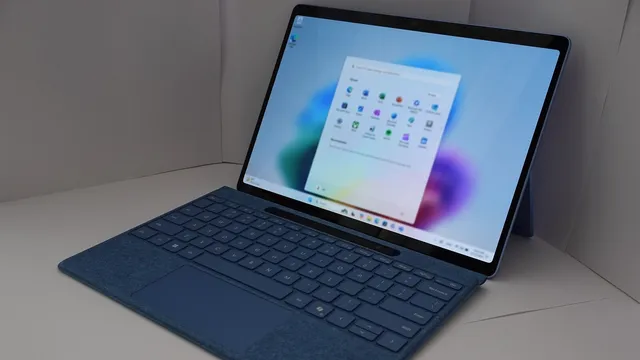 Computador portátil Surface com teclado azul, com o menu Iniciar do Windows 11 aberto no ecrã