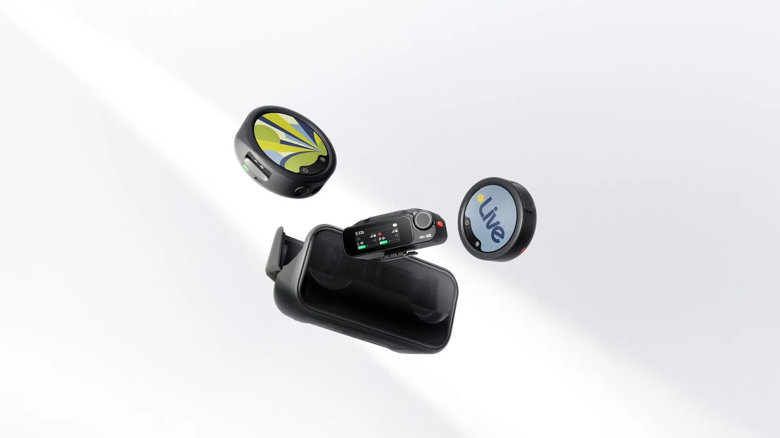 Dois emissores redondos do Insta360 Mic, um com um desenho colorido e outro com a palavra Live no ecrã, ao lado de um recetor com ecrã e do estojo de carregamento preto