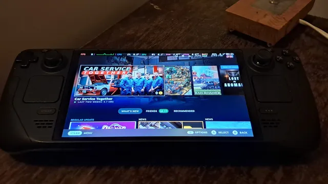 Consola portátil Steam Deck OLED pousada numa mesa, com o ecrã inicial da Steam a mostrar a biblioteca de jogos