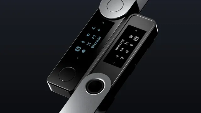 Duas carteiras físicas Ledger Nano em preto e cinzento, vistas de perto, com o ecrã a mostrar ícones de criptomoedas
