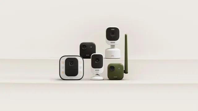 Cinco câmaras de vigilância Blink em preto, branco e verde, de vários formatos, pousadas em degraus de cor creme
