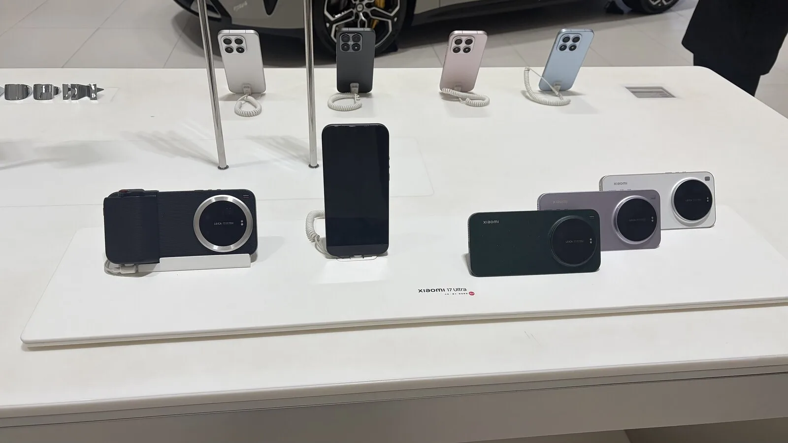 Vários telemóveis Xiaomi 17 Ultra expostos numa mesa branca de loja, vistos de trás, com o grande módulo de câmara circular