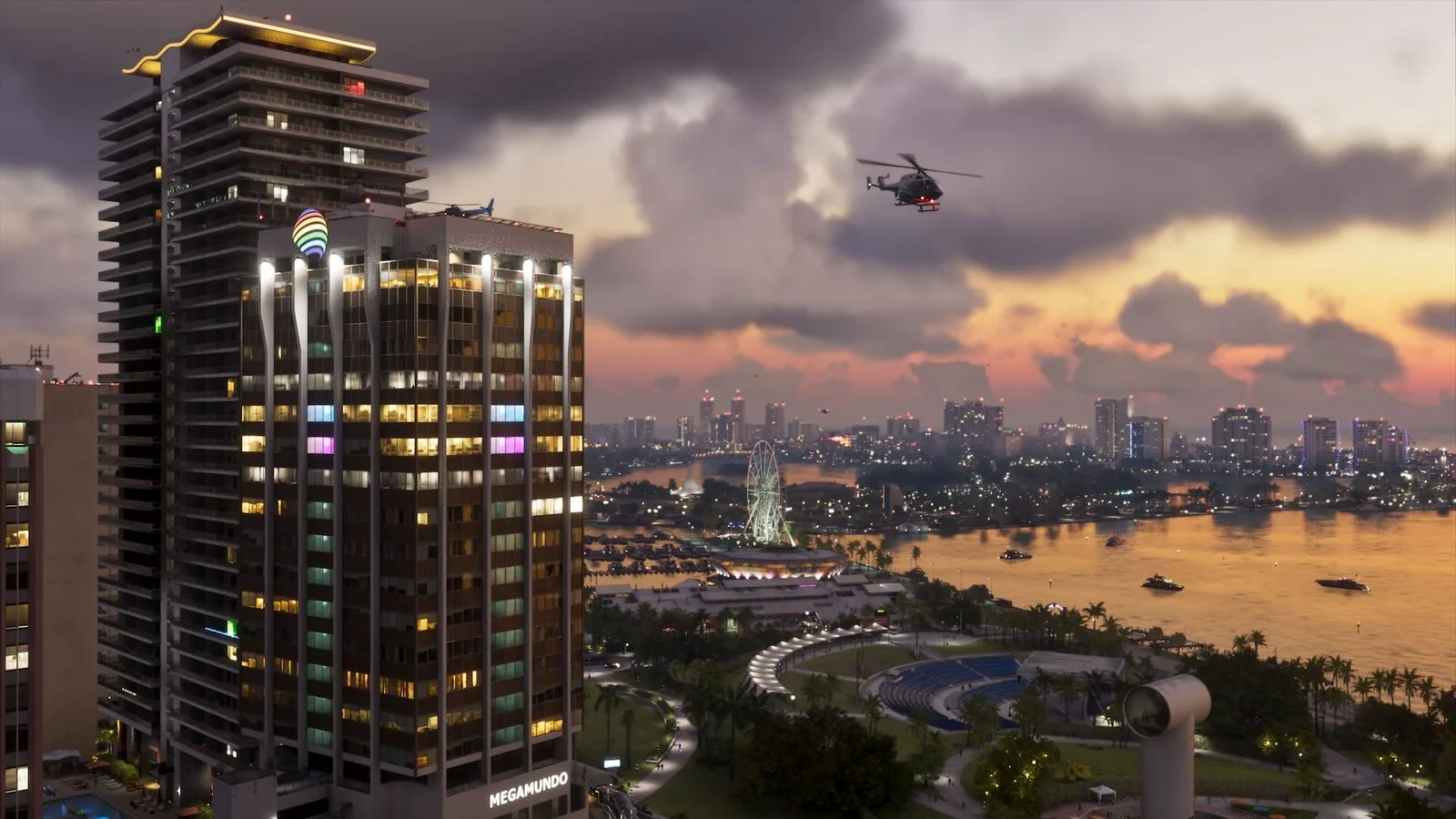 Imagem do jogo com um arranha-céus iluminado e um helicóptero sobre a baía de Vice City ao pôr do sol