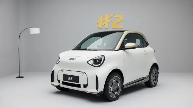 smart #2 Couture Edition branco mate com tejadilho dourado, visto de frente a três quartos num estúdio cinzento
