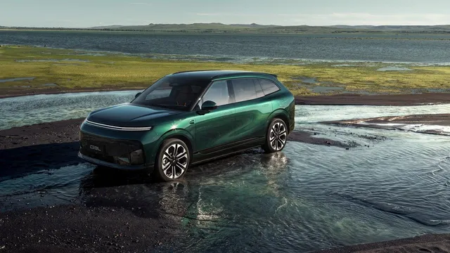 SUV XPENG G9L verde-escuro parado numa zona alagada, com uma paisagem de planície ao fundo